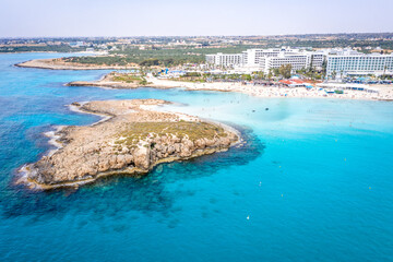 Aerial view of the most famous beaches in Cyprus - Nissi Beach. White sand beach with azure waters. Beautiful beach and panoramic views of Cyprus