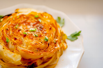 Oven baked cabbage with spices close-up,Roasted vegetables, Vegan cuisine, white cabbage  steak recipe. Homemade authentic dish, baked vegetables background. Healthy food concept, vegetable side 