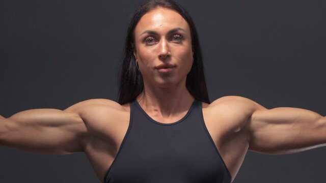 Muscular female bodybuilder woman workout arms: biceps and triceps in the gym. Sport and health care concept