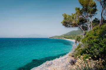 Blue sea on the Turkish coast. Azure water and trees as a background. Dilek National Park,...