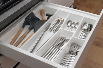 Open drawer with utensil set. Kitchen storage organization system. Modern kitchen