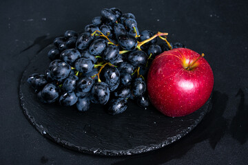 Brushes of black grapes on a dark background
