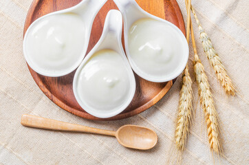 Greek yogurt in a wooden bowl and dry barley.