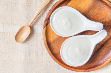 Greek yogurt in a wooden bowl and dry barley.