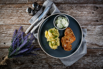 Pork chop served with mashed potatoes and cucumber salad.