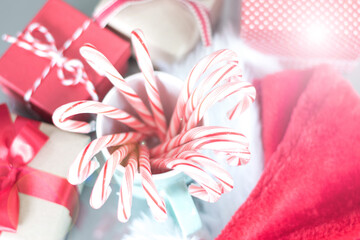 Candy canes in pastel cup with red gift boxes for Christmas background decoration