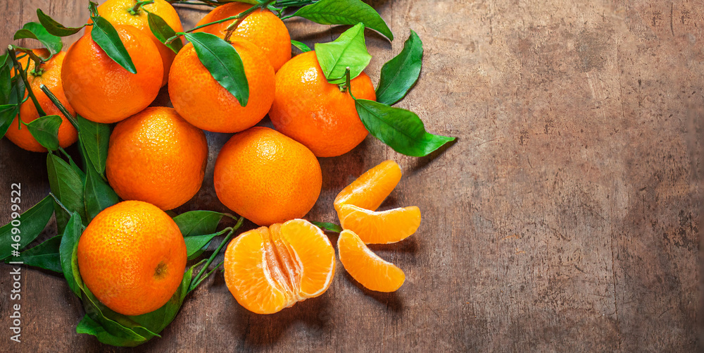 Wall mural mandarin oranges fruits or tangerines with leaves on a wooden table. copyspace. fresh picked mandari