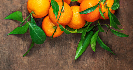 Mandarin oranges fruits or tangerines with leaves on a wooden table. Copyspace. Fresh picked...