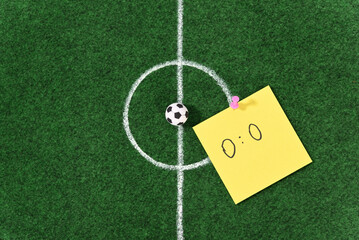 Soccer ball in the center of the soccer field and stationery push pins. © Homestudio