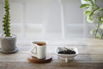 Fototapeta na wymiar Small heart tea cup and tea pile on wooden table