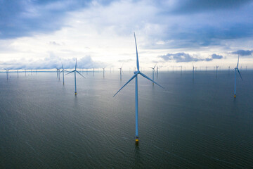 Drone photography of enormous windmills stand in the sea along a dutch sea. Fryslân wind farm, the largest inland wind farm in the world. Friesland, Afsluitdiijk, Ijsselmeer, Breezanddijk, Netherlands