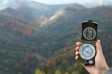 Naklejka premium Woman using compass during journey in mountains, closeup