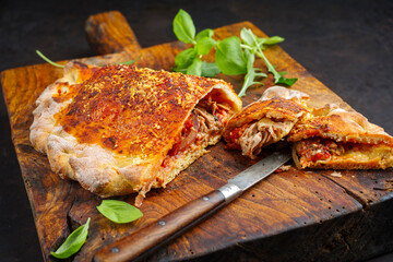 Traditionelle italienische Pizza Calzone mit Thunfisch und Zwiebeln serviert als close-up auf einem...