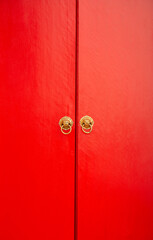 Chinese style wooden red door with lion heads.