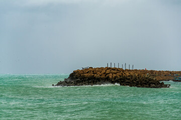 view from the rocky beaches in chabahar with cloudy sky, baluchistan province, iran