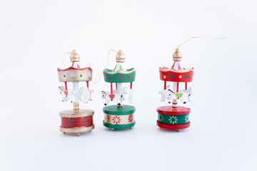 Wooden Christmas toy for the Christmas tree. Eco-friendly toy for Christmas. A small red, green and gold carousel in the form of a tent with white horses made of wood