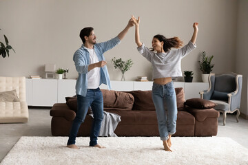 Full length loving young couple dancing in living room together, dating, handsome young husband...