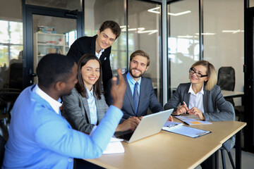 startup business team on meeting in modern bright office interior brainstorming, working on laptop and computer.
