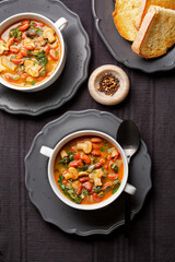 Italian vegetable soup with bean, mushroom, tomatoes and chard. Zimino di fagioli. Toasted bread. Vertical image.