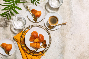 Italian summer breakfast. Rum baba and coffee espresso, glasses of water.  Light stone background, top view, copy space.