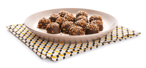 Plate with tasty flax seed candies on white background