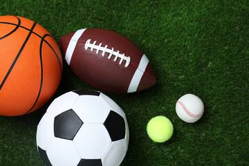 Set of different sport balls on green grass, flat lay
