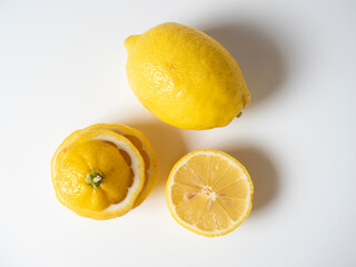 Close-up of a cut and whole lemon lying on a white background. isolated fruit. Sour yellow fruit full of vitamins. Top view, flat lay