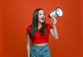 Young girl with megaphone announcing sale yelling at loudspeaker, black Friday shopping on orange...