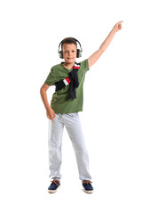 Fototapeta premium Dancing little boy listening to music, isolated on white