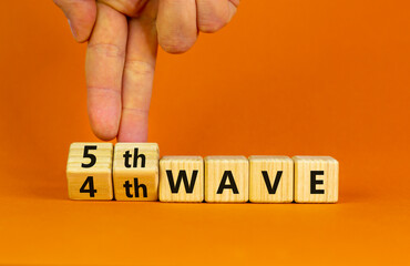 Symbol for a fifth wave of the covid-19 corona virus. Doctors turns cubes and changes words '4th wave' to '5th wave'. Beautiful orange background. Fifth wave of the covid-19 concept. Copy space.