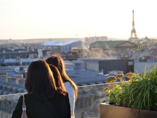 Fototapeta na wymiar Some people looking at the beautiful sunset from a parisian roof. October 2021, Paris, France.
