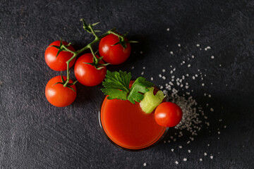 Glass of bloody mary with celery and tomatoes on dark background © Pixel-Shot