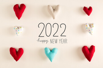Happy New Year 2022 message with blue heart cushions on a white paper background