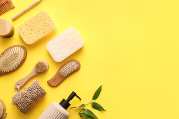 Set of bath supplies with sponges and massage brushes on yellow background