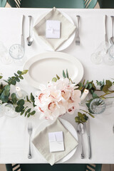 Beautiful table setting for wedding celebration with burning candles in restaurant