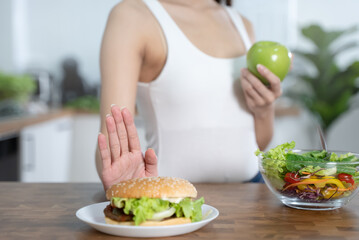 Fototapeta na wymiar Women avoid fast food during diet sessions to lose weight and choose healthy food that has vitamins and nutrition.
