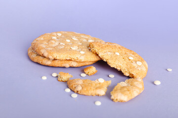 Tasty broken cookies with chocolate chips on color background