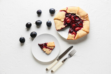 Composition with delicious plum galette on white background