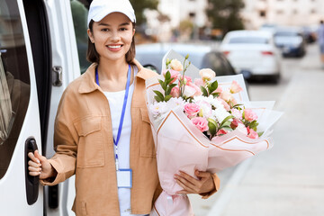 Female courier with bouquet of flowers near car outdoors
