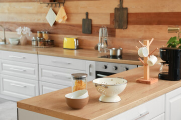Fototapeta na wymiar Kitchen counters with different utensils near wooden wall