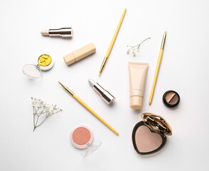 Set of decorative cosmetics with makeup brushes on white background