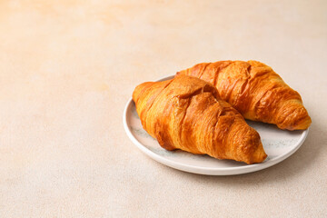 Plate with delicious croissants on white background