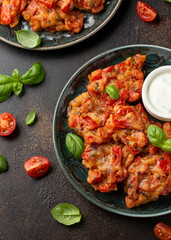Greek tomato fritters, tomatokeftedes served with yogurt on plate.