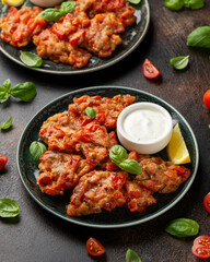 Greek tomato fritters, tomatokeftedes served with yogurt on plate.