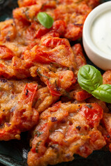Greek tomato fritters, tomatokeftedes served with yogurt on plate.