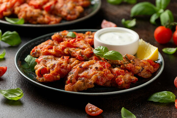 Greek tomato fritters, tomatokeftedes served with yogurt on plate.