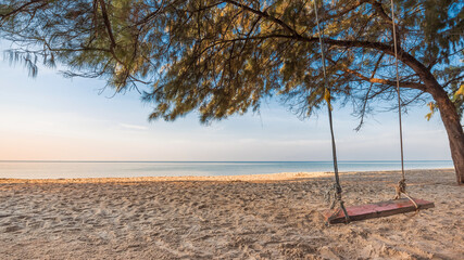 relaxing on the beach with rope swing under the pine  in summer vacation time