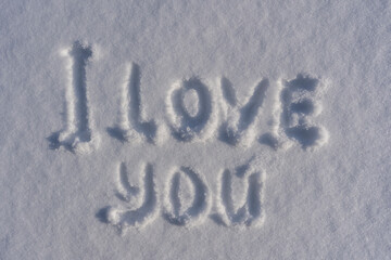 Text I love you on a white fresh snow in winter, close up