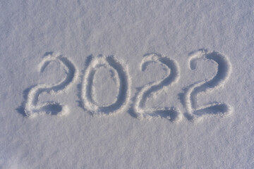 Happy new year 2022 sign text written with numbers from snow on snow surface