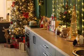 Kitchen counters with Christmas gifts and decor near green wall